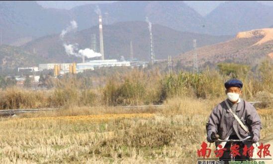 1月15日,仁化县五一村一家冶炼厂正在生产。一位村民戴着口罩从村道经过。 □刘龙飞 摄 仁化上坝村土壤污染严重。政府和学者正探索各种治理方式。谈及前景,专家坦言——"土壤修复长期艰巨"